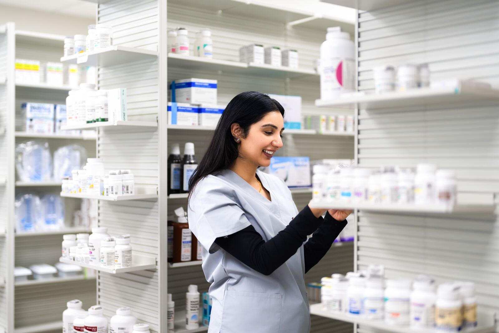 A pharmacist checking medication on the shelves at OnPoint Carle Place