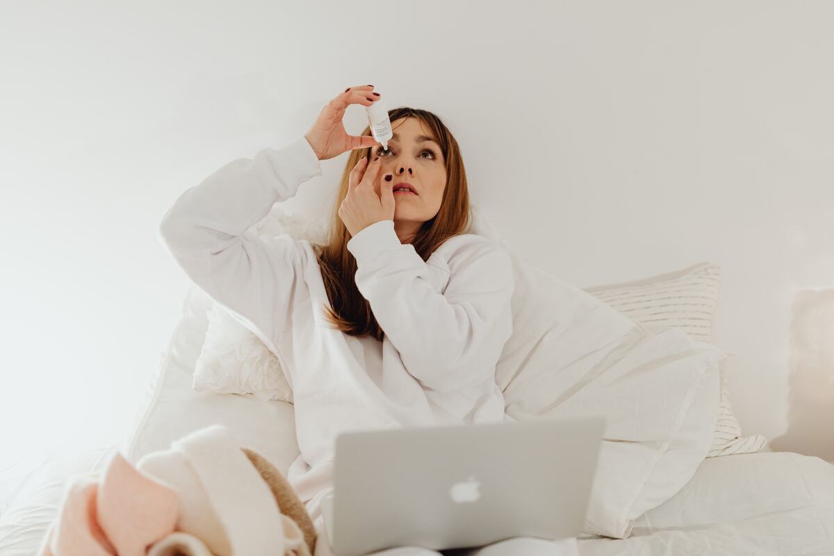 A person putting in an eye drop